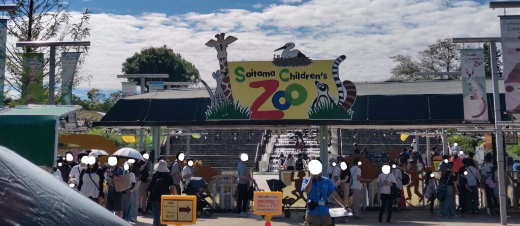 こども動物自然公園の正門と、入園券を買う人の案内板